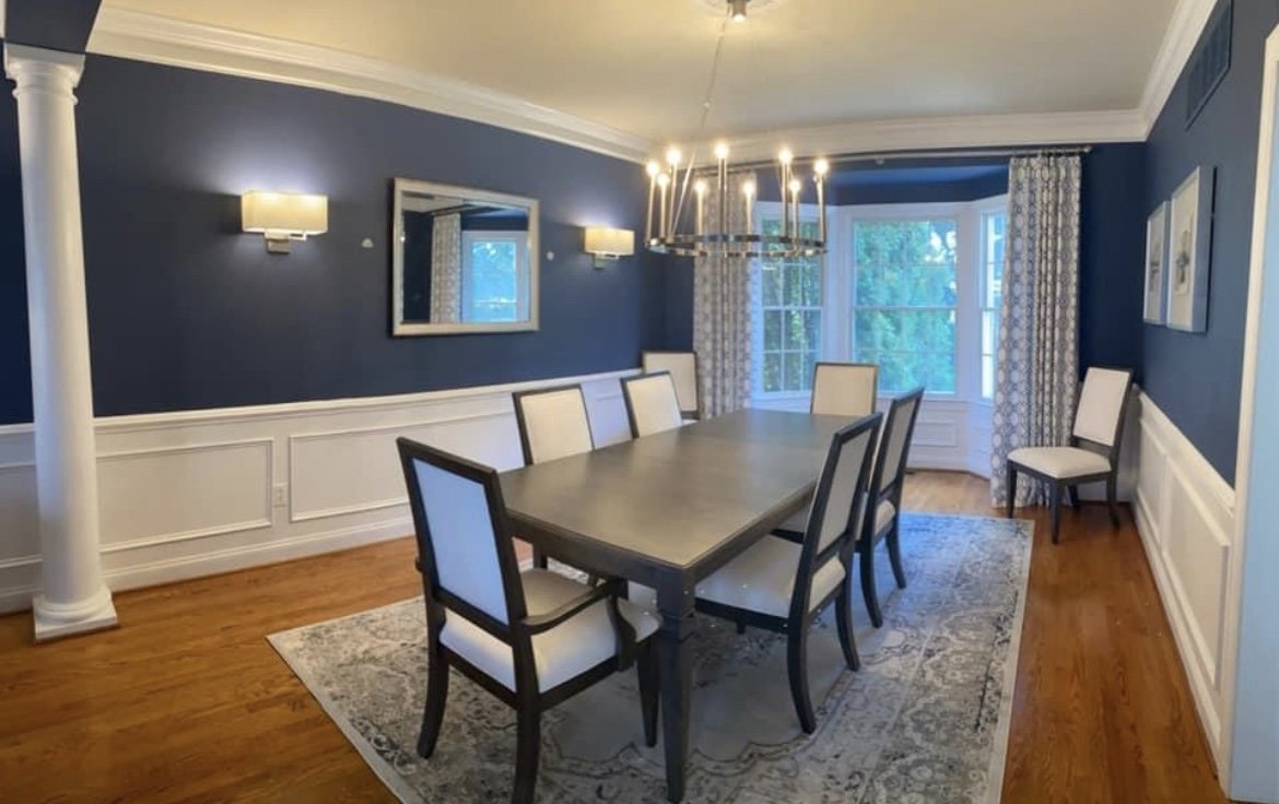 Formal dining room with navy walls and white wainscoting